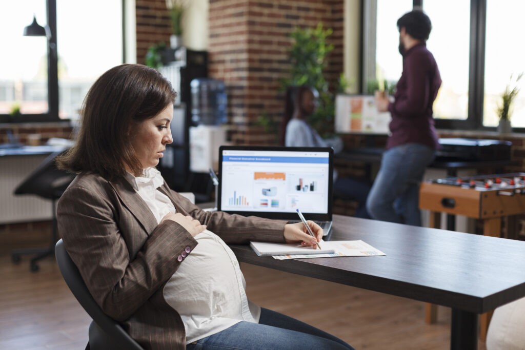 Pregnant woman analyzing economic growth of company and reviews financial and management chart.